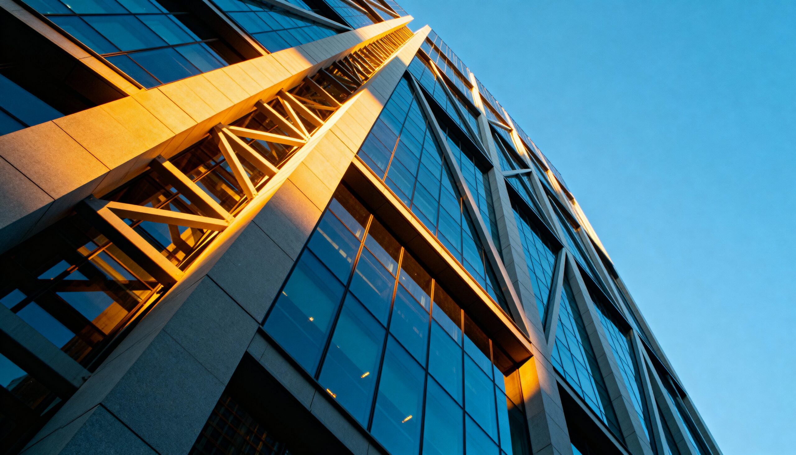 sunlit modern building facade against clear blue sky